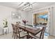 Dining area features a wooden table, seating for six, modern lighting, and sliding door access to the patio at 16750 Sunburst Lake St, Wimauma, FL 33598