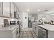 Modern kitchen featuring granite countertops, stainless steel appliances, gray cabinets and a breakfast bar at 16750 Sunburst Lake St, Wimauma, FL 33598