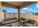 Covered outdoor patio with comfortable wicker furniture, perfect for relaxing and enjoying the backyard view at 16750 Sunburst Lake St, Wimauma, FL 33598