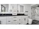 Bathroom featuring double sinks with black granite countertops and sleek fixtures at 4907 Parson Brown Ln, Palm Harbor, FL 34684