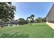 Spacious waterfront backyard with lush lawn, mature palms, and dock access for waterfront living at 5497 56Th E Ct, Bradenton, FL 34203