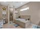 Bathroom showcasing a luxurious soaking tub, walk-in shower, and neutral tile at 5497 56Th E Ct, Bradenton, FL 34203