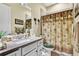 Bathroom showcasing a granite vanity, framed mirror, and shower with curtain at 5497 56Th E Ct, Bradenton, FL 34203