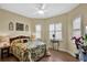 Cozy bedroom featuring plantation shutters, wood floors, and ceiling fan at 5497 56Th E Ct, Bradenton, FL 34203