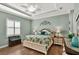 Bright bedroom featuring a ceiling fan, plantation shutters, and wood flooring at 5497 56Th E Ct, Bradenton, FL 34203