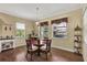Bright breakfast nook with a round table and wicker chairs, with views of the screened in lanai and backyard at 5497 56Th E Ct, Bradenton, FL 34203