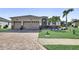 Charming single-story home featuring a two-car garage, landscaped yard with decorative stone and palm trees at 5497 56Th E Ct, Bradenton, FL 34203