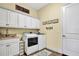 Bright laundry room featuring white cabinets, washer, dryer, and stylish decor at 5497 56Th E Ct, Bradenton, FL 34203