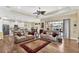 Open-concept living room with hardwood floors, coffered ceiling, fan, and access to the outdoor patio at 5497 56Th E Ct, Bradenton, FL 34203