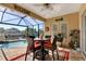 Relaxing screened-in patio with dining set and tranquil pool and lake view at 5497 56Th E Ct, Bradenton, FL 34203