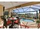 Beautiful covered patio with dining area, pool, and serene lake views at 5497 56Th E Ct, Bradenton, FL 34203
