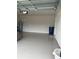 Shows a spacious garage with epoxy flooring and ample storage space with overhead door at 17130 11Th Ter E, Bradenton, FL 34212