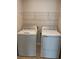 Functional laundry area with a modern washer, dryer, and storage shelf above at 17130 11Th Ter E, Bradenton, FL 34212
