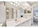 Bathroom with double sinks, large mirror, and white cabinets at 6151 Bahia Del Mar Blvd # 125, St Petersburg, FL 33715