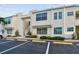 Beige condo building featuring reserved parking, stairs to upper units, and tidy landscaping at 6151 Bahia Del Mar Blvd # 125, St Petersburg, FL 33715