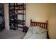 Simple bedroom with neutral walls, industrial style shelf with desk, and patterned bedspread at 10308 Soaring Eagle Dr, Riverview, FL 33578
