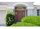 Inviting front entrance framed by lush greenery, offering a warm welcome at 10308 Soaring Eagle Dr, Riverview, FL 33578