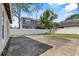 Spacious backyard with a concrete patio, surrounded by a white privacy fence and mature trees at 4408 W Prescott St, Tampa, FL 33616