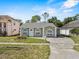 Charming single-story home featuring arched windows, a carport, and a well-maintained front lawn at 4408 W Prescott St, Tampa, FL 33616