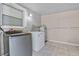 A utility area featuring a washer, dryer, water heater, and natural light from the window at 4408 W Prescott St, Tampa, FL 33616