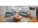Bright, neutral living room featuring tile flooring, a blue patterned rug, and comfortable seating; virtually staged at 4408 W Prescott St, Tampa, FL 33616