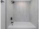 Bathtub with white marble tile walls and a modern, matte black shower head and fixtures at 5151 Puritan Cir # 1022, Tampa, FL 33617