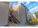 Exterior view of condo building featuring neutral siding, a stairway, and manicured landscaping at 5151 Puritan Cir # 1022, Tampa, FL 33617