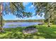 Picturesque lake view featuring a bench, lush greenery, and a serene waterfront, ideal for relaxation and nature enjoyment at 5151 Puritan Cir # 1022, Tampa, FL 33617
