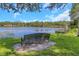 Picturesque lake view featuring a bench, lush greenery, and a serene waterfront, ideal for relaxation and nature enjoyment at 5151 Puritan Cir # 1022, Tampa, FL 33617