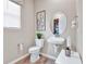 Charming half bathroom featuring a pedestal sink, decorative mirror, and neutral tones at 9195 Players Dr, Weeki Wachee, FL 34613