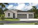 Charming single-story home featuring a three-car garage and well-maintained front lawn at 9210 Players Dr, Weeki Wachee, FL 34613