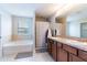 Well-lit bathroom with double sinks, a soaking tub, and separate shower with neutral decor at 2746 Walden Woods Dr, Plant City, FL 33566