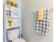 Bright bathroom featuring white over the toilet shelving unit and decorative daisy-themed towels at 2746 Walden Woods Dr, Plant City, FL 33566