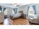 Cozy bedroom featuring wood floors, neutral walls, a ceiling fan, and plenty of natural light at 2746 Walden Woods Dr, Plant City, FL 33566