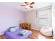 Colorful bedroom featuring a purple comforter, wood floors, and a cozy beanbag chair at 2746 Walden Woods Dr, Plant City, FL 33566