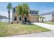 Charming two-story home featuring a green lawn, attached two-car garage, and beautifully arranged landscaping at 2746 Walden Woods Dr, Plant City, FL 33566