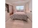 Comfortable bedroom with a floral patterned bedspread, white tile floors, and natural light at 870 Virginia St # 108, Dunedin, FL 34698