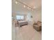 Cozy bedroom featuring tile floors, modern lighting, and a comfortable armchair at 870 Virginia St # 108, Dunedin, FL 34698