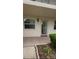 Charming condo entrance with a decorative wreath on the door and well-maintained landscaping at 870 Virginia St # 108, Dunedin, FL 34698