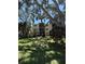 Exterior of a three-story building with balconies, lush greenery, and mature trees offering shade and curb appeal at 870 Virginia St # 108, Dunedin, FL 34698