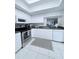 Modern kitchen with stainless steel appliances, white cabinets, and tile flooring at 870 Virginia St # 108, Dunedin, FL 34698