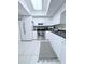 Well-lit kitchen with modern appliances, white cabinetry, and decorative rug at 870 Virginia St # 108, Dunedin, FL 34698