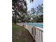 Community pool featuring an American flag and ample seating under the shade of mature trees at 870 Virginia St # 108, Dunedin, FL 34698