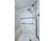 Close-up of a shower with grab bars, shower head, and tiled walls at 870 Virginia St # 108, Dunedin, FL 34698