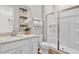 Bathroom vanity with white cabinets, decorative art, and a glass-enclosed shower at 9253 Players Dr, Weeki Wachee, FL 34613