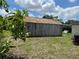 Backyard shed featuring a corrugated roof with mature trees at 1009 Kenmore Dr, Brandon, FL 33510