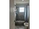 Bathroom with tiled walls and shower, featuring a window for natural light at 1009 Kenmore Dr, Brandon, FL 33510