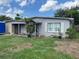 Exterior view of home with beautiful landscaped yard, and covered entry, offering a warm welcome at 1009 Kenmore Dr, Brandon, FL 33510