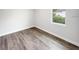 An empty bedroom offers wood look floors and a window overlooking the outdoors at 17381 Tyler Ave, Port Charlotte, FL 33948