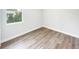 An empty bedroom offers wood look floors and a window overlooking the outdoors at 17381 Tyler Ave, Port Charlotte, FL 33948